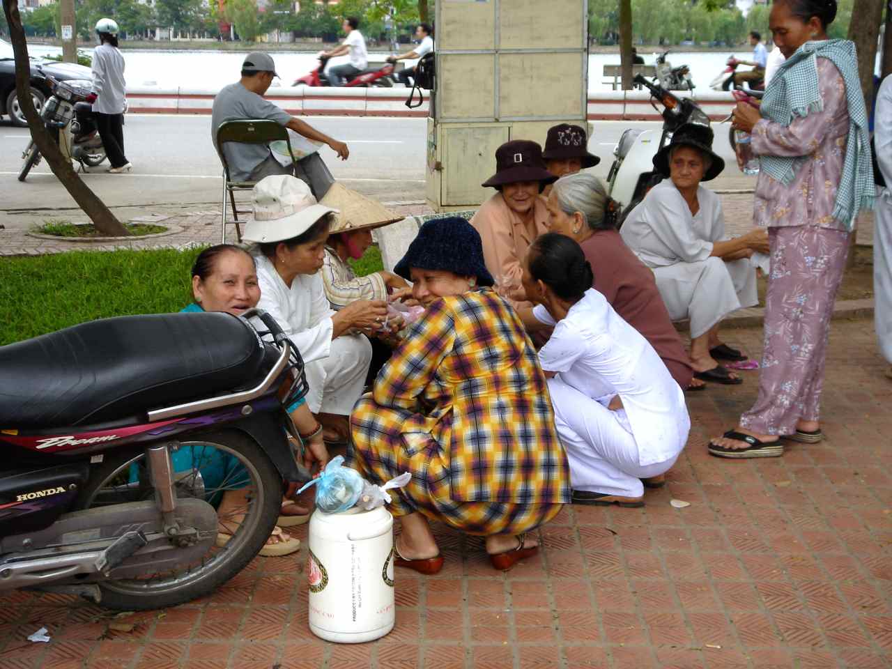 mujeres sentadas junto a La Pagoda de Tran Quoc en Hanoi (Vietnam)
